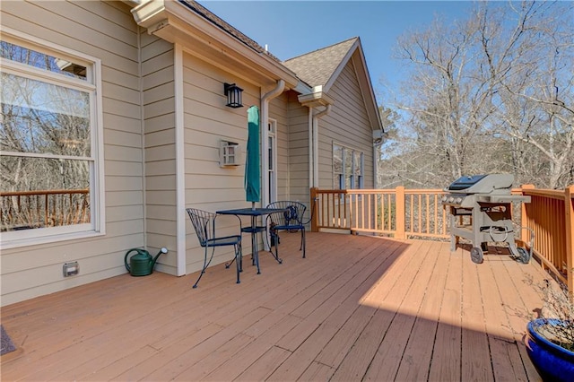 deck with a grill and outdoor dining space