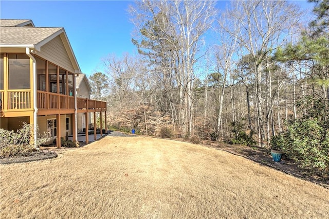 view of yard featuring a sunroom and a patio area