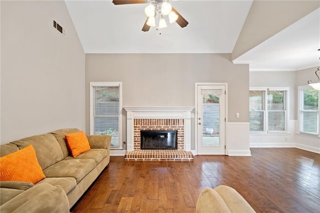 living room with ornamental molding, ceiling fan, high vaulted ceiling, a fireplace, and dark hardwood / wood-style floors