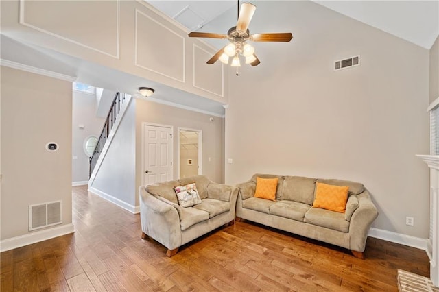 living room featuring a brick fireplace, ornamental molding, ceiling fan, high vaulted ceiling, and dark hardwood / wood-style floors