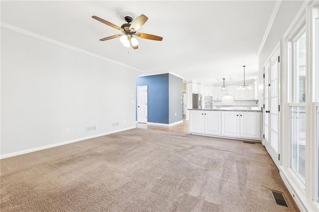 unfurnished living room with visible vents, crown molding, light carpet, and baseboards