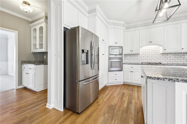 kitchen featuring stainless steel appliances, stone countertops, white cabinets, and crown molding