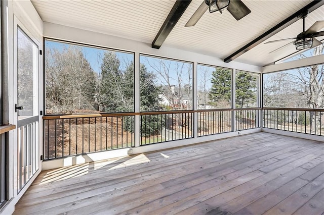 unfurnished sunroom featuring lofted ceiling with beams, ceiling fan, and a wealth of natural light