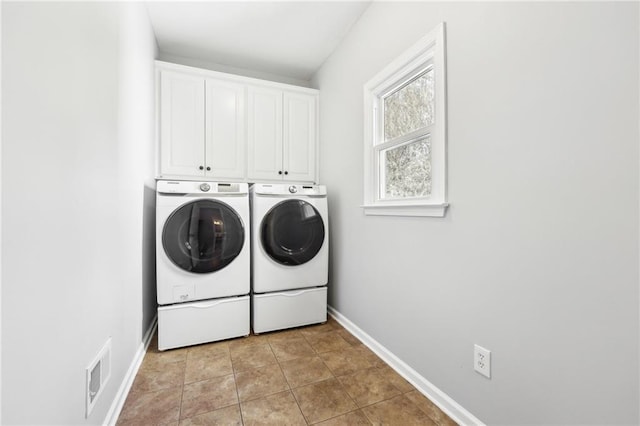 laundry area with washer and clothes dryer, visible vents, cabinet space, light tile patterned flooring, and baseboards