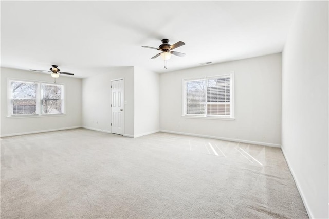 carpeted spare room with a ceiling fan, visible vents, and baseboards