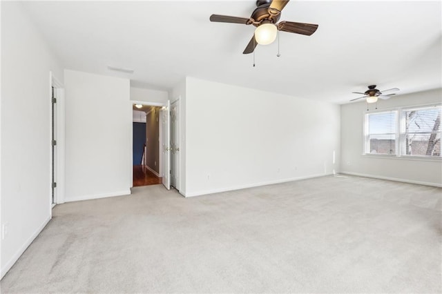 empty room featuring light colored carpet and baseboards