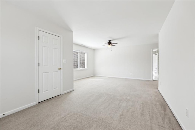 spare room with carpet flooring, a ceiling fan, and baseboards