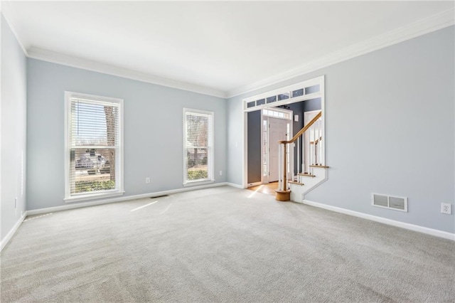 unfurnished room featuring plenty of natural light, visible vents, carpet flooring, and ornamental molding