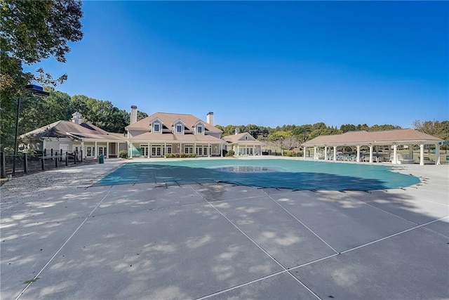 pool with a patio area and fence