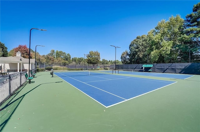 view of tennis court featuring fence