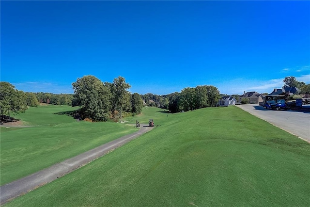 view of community with a lawn and golf course view