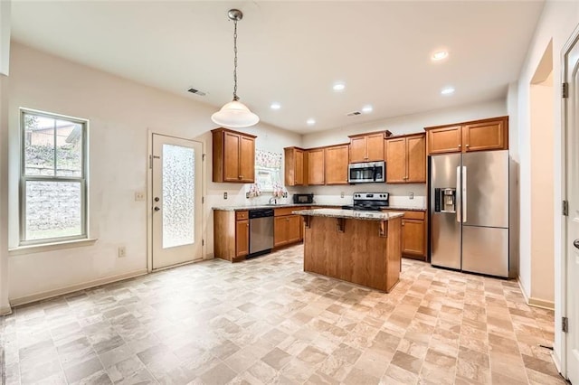 83 Marmalade Trl, Dawsonville, GA 30534 - kitchen featuring appliances with stainless steel finishes, brown cabinetry, a kitchen island, recessed lighting, and decorative light fixtures