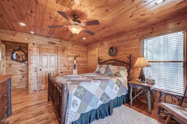 bedroom featuring wood ceiling, light wood finished floors, and multiple windows