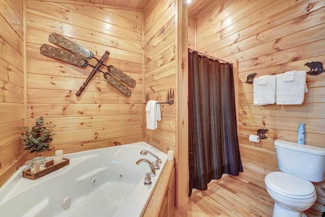 full bathroom featuring a jetted tub, wood walls, a shower with shower curtain, and toilet