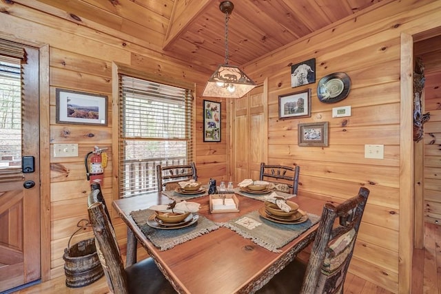 dining space featuring wood ceiling, wood walls, a wealth of natural light, and wood finished floors