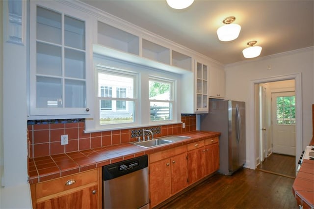 kitchen with sink, appliances with stainless steel finishes, tile countertops, dark wood-type flooring, and tasteful backsplash