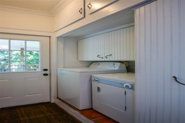 clothes washing area featuring dark hardwood / wood-style flooring, separate washer and dryer, and cabinets