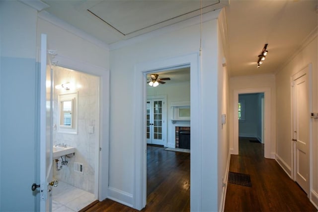 hallway with french doors, dark wood-type flooring, and rail lighting