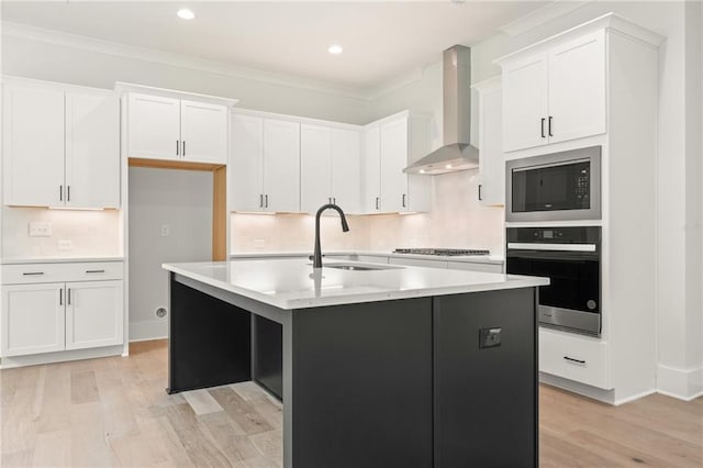 kitchen featuring wall chimney range hood, sink, stainless steel microwave, backsplash, and oven