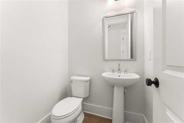 bathroom featuring wood-type flooring and toilet