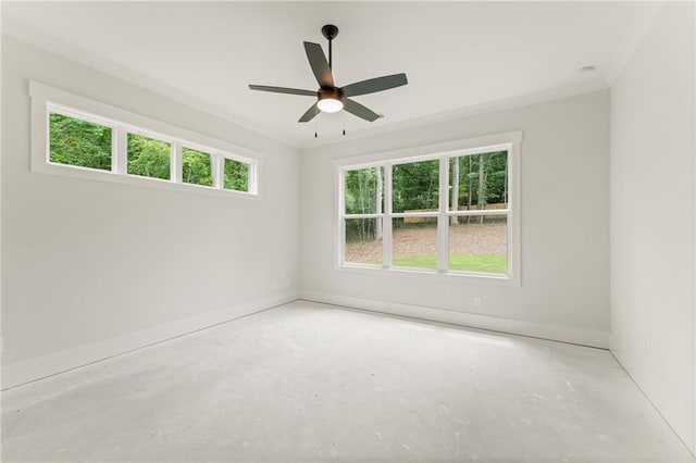 empty room featuring a healthy amount of sunlight, concrete flooring, ornamental molding, and ceiling fan