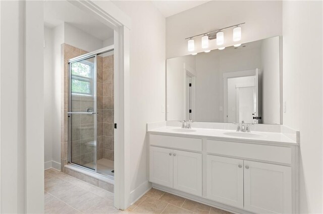 bathroom featuring double vanity, tile patterned floors, and a shower with door