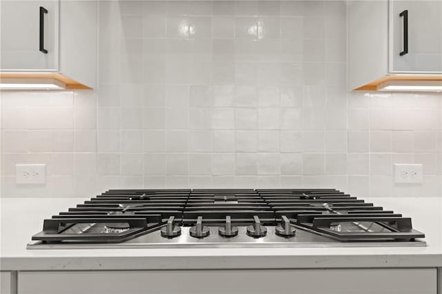 interior details with backsplash and stainless steel gas cooktop