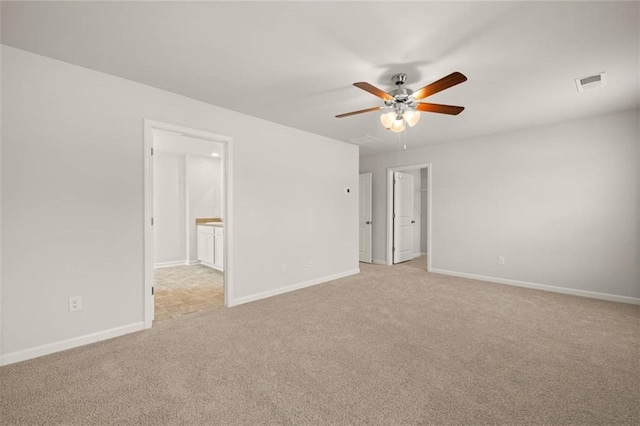 spare room with light colored carpet and ceiling fan