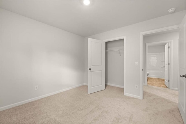 unfurnished bedroom featuring light colored carpet and a closet