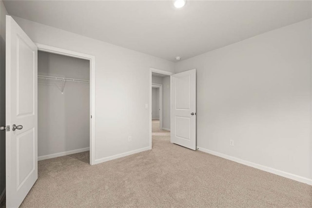 unfurnished bedroom featuring light colored carpet and a closet