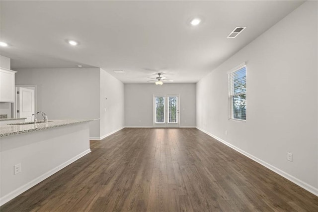 unfurnished living room featuring dark hardwood / wood-style flooring, sink, and ceiling fan