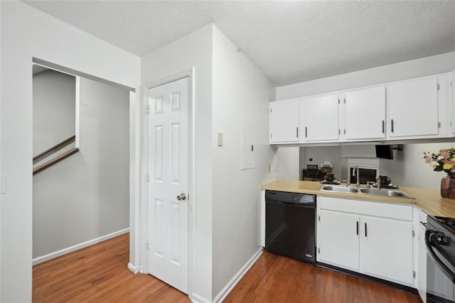 kitchen with baseboards, dark wood finished floors, a sink, and black appliances