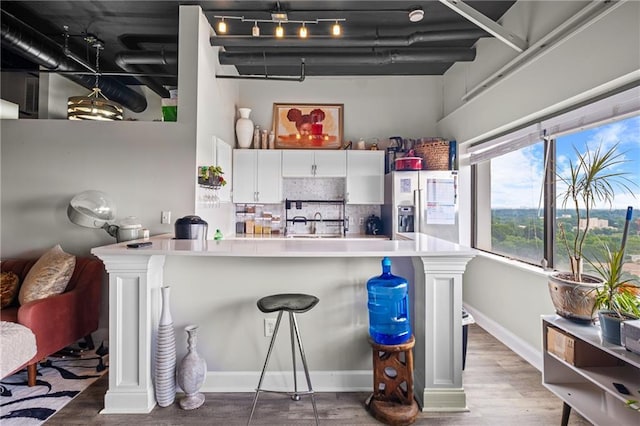 120 Ralph Mcgill Blvd NE Unit 1409, Atlanta, GA 30308 - kitchen with stainless steel fridge with ice dispenser, white cabinets, wood finished floors, and backsplash