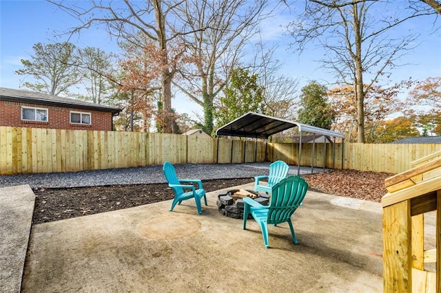 view of patio featuring a carport, a fire pit, and a fenced backyard