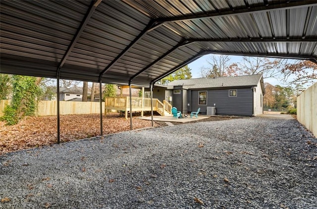 view of vehicle parking with fence and a carport