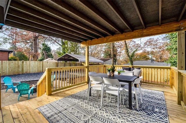 wooden deck with a fenced backyard and outdoor dining area