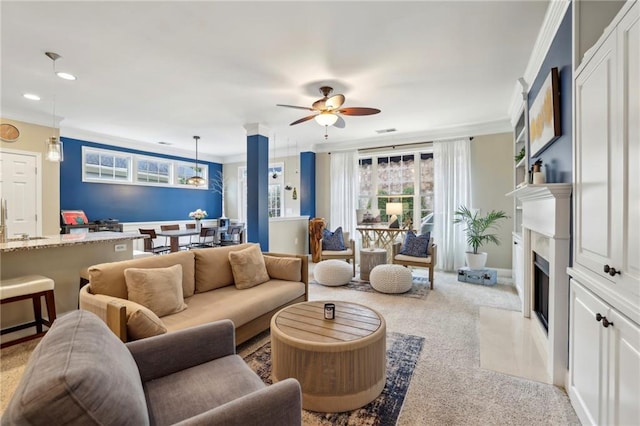 carpeted living room with baseboards, a ceiling fan, a fireplace with flush hearth, ornamental molding, and recessed lighting