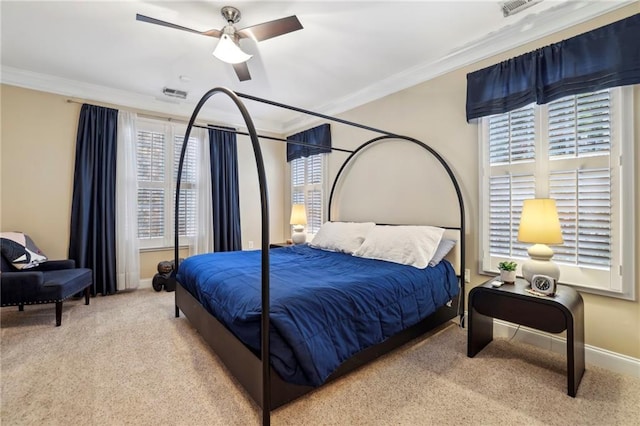 carpeted bedroom featuring baseboards, ceiling fan, visible vents, and crown molding