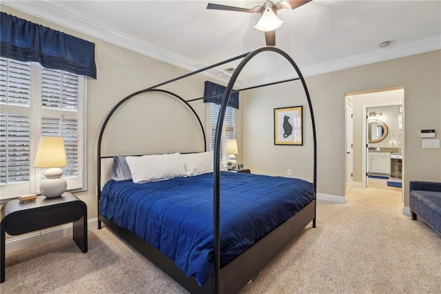 carpeted bedroom featuring ceiling fan, ornamental molding, ensuite bath, and baseboards