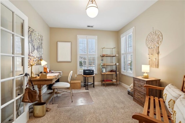 carpeted office featuring visible vents and baseboards