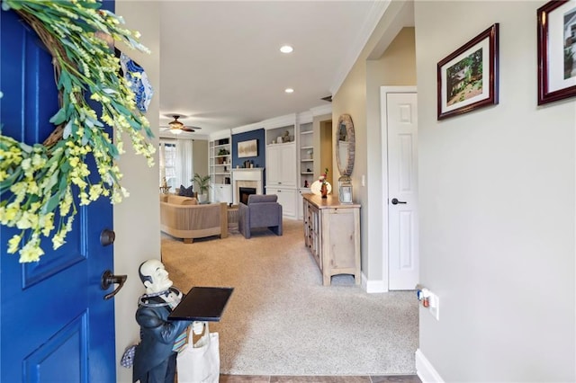 entryway featuring baseboards, ornamental molding, carpet flooring, a fireplace, and recessed lighting