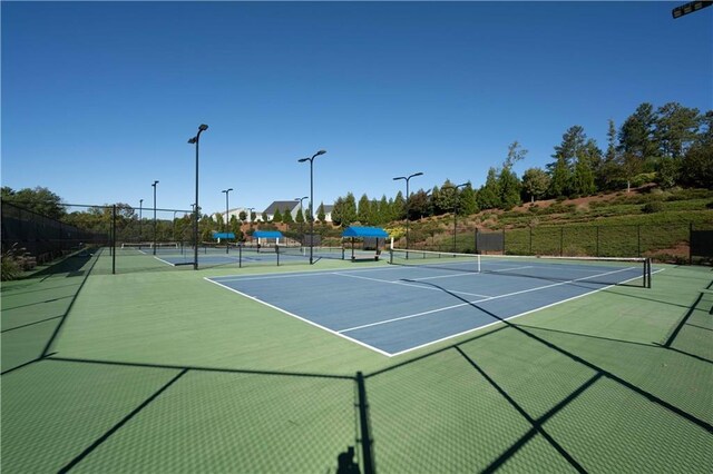 view of tennis court featuring basketball hoop