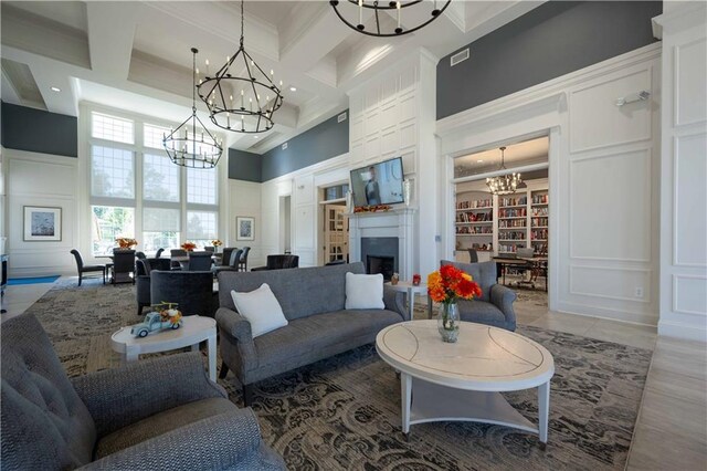 living room with coffered ceiling, built in shelves, a towering ceiling, ornamental molding, and beamed ceiling