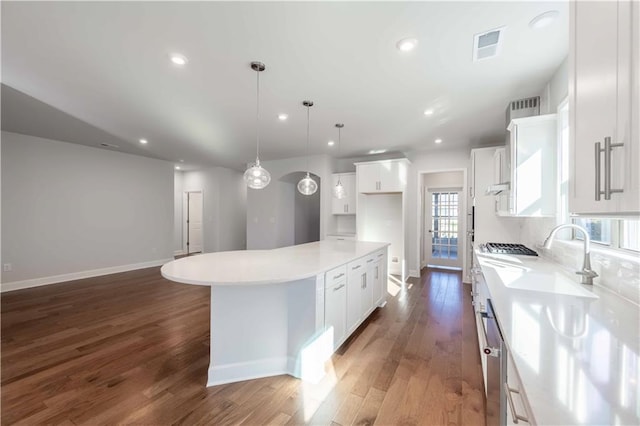 kitchen featuring white cabinets, pendant lighting, a center island, and dark hardwood / wood-style floors