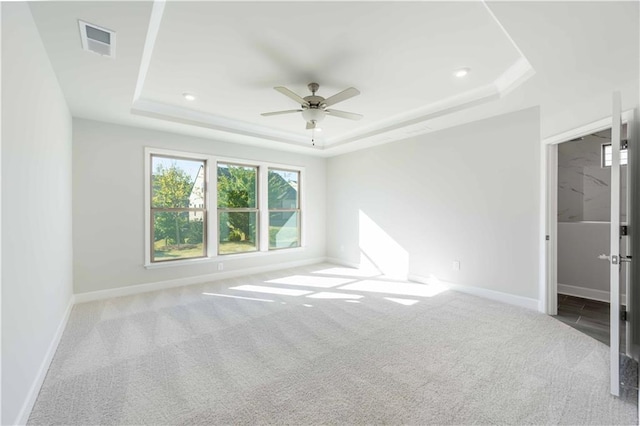 unfurnished bedroom with carpet, ceiling fan, and a raised ceiling