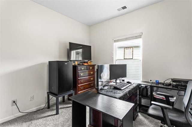 carpeted home office featuring visible vents and baseboards