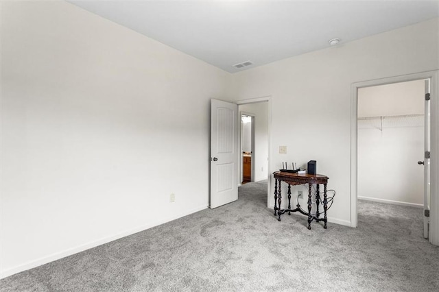 carpeted bedroom featuring baseboards, visible vents, a closet, and a spacious closet