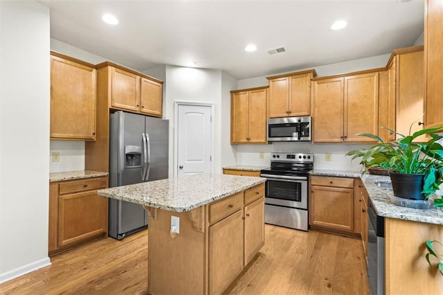 kitchen featuring a center island, stainless steel appliances, light wood-style flooring, and visible vents