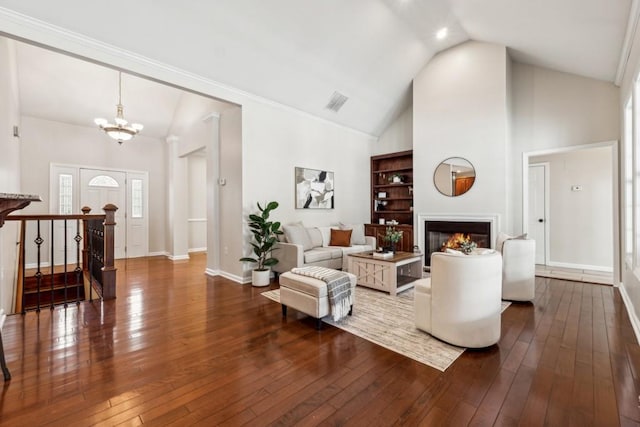 living room with a notable chandelier, dark hardwood / wood-style flooring, and high vaulted ceiling