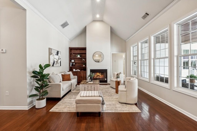 living room featuring hardwood / wood-style flooring, vaulted ceiling, a wealth of natural light, and ornamental molding